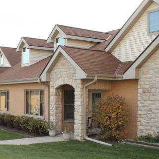 A suburban house with a brick exterior and well-maintained lawn.