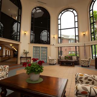 A spacious and elegantly designed lobby featuring large windows, comfortable seating, and decorative plants.