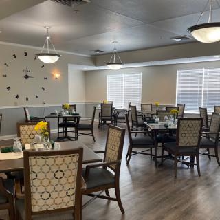 A well-lit dining area with neatly arranged tables and chairs.
