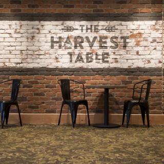 A cozy restaurant interior featuring an industrial design with brick walls and simple furniture.