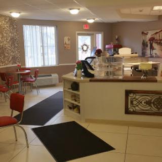 A cozy caf interior featuring a welcoming counter and bright seating arrangements.