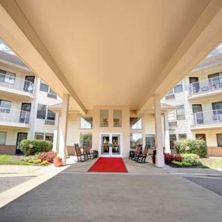 Entrance of a building featuring a red carpet and landscaped surroundings.