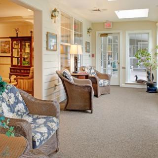 A cozy living room with wicker furniture and ample natural light from a skylight.