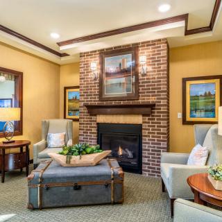 A cozy living room with a warm fireplace, elegant furniture, and tasteful artwork.
