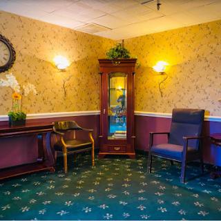 A cozy seating area featuring elegant furniture, decorative wallpaper, and warm lighting.
