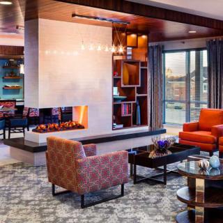 A modern living room with a cozy fireplace and stylish furnishings.