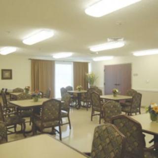 A well-lit dining area with several tables and chairs arranged neatly.