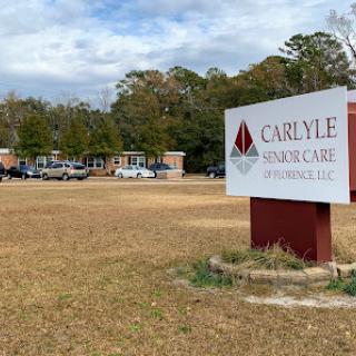A view of the Carlyle healthcare facility with a prominent sign in the foreground.