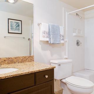 A clean and modern bathroom with a granite countertop.