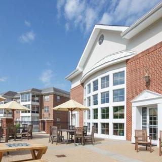 A sunny day view of a residential apartment building with an outdoor patio area.