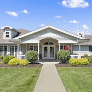 A charming house with well-maintained landscaping under a clear blue sky.