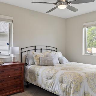 A cozy and inviting bedroom featuring a comfortable bed, stylish nightstand, and ample natural light.
