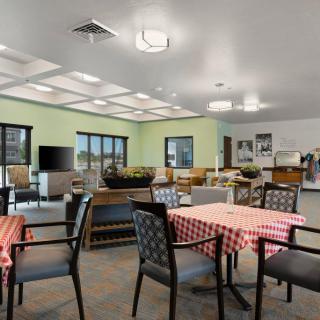 A cozy dining area with tables covered in checkered tablecloths and comfortable seating.