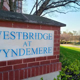 Entrance sign for Westbridge at Wyndemere surrounded by landscaping.