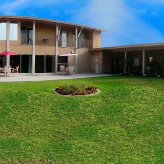 A modern house with a well-maintained lawn under a clear blue sky.