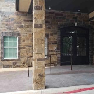 A building entrance with a stone wall and a window.