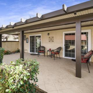A covered patio with outdoor seating and a garden view.