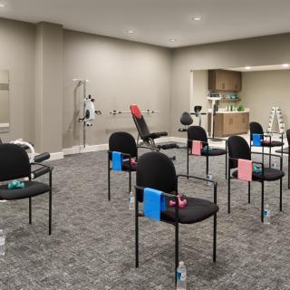 A modern rehabilitation clinic setup with chairs and exercise equipment.