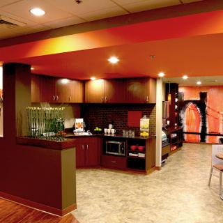 A modern and colorful lounge area featuring a kitchen space designed for hospitality.