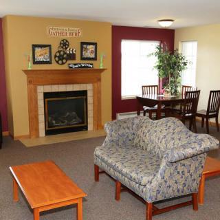A cozy living room with a fireplace and a connected dining area.
