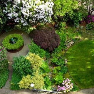 A beautiful aerial view of a lush garden featuring well-maintained greenery, colorful flowers, and neatly arranged bushes.