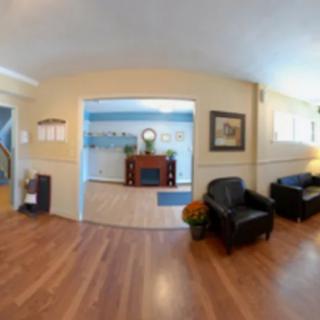 A cozy living room with wood flooring and comfortable seating.