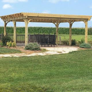 A wooden gazebo in a scenic garden landscape.