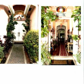 A picturesque entrance and hallway adorned with lush plants and classic architectural details.
