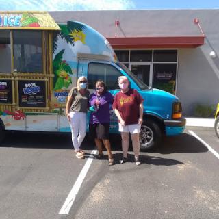 A group of friends enjoying a sunny day outside a colorful food truck.