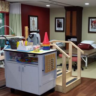 A rehabilitation room equipped with therapy equipment and furniture.