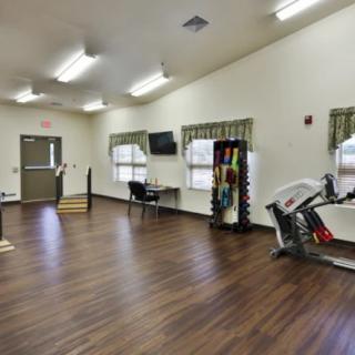 A spacious gym with fitness equipment and weights.
