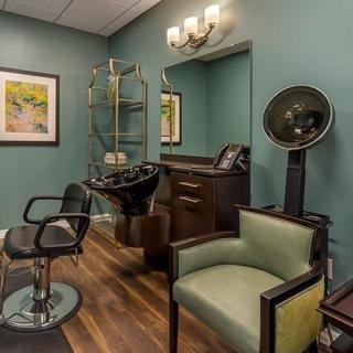 A cozy hair salon with modern furnishings and artwork on the walls.