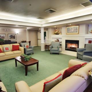 A cozy living room featuring multiple sofas and chairs arranged around a fireplace.