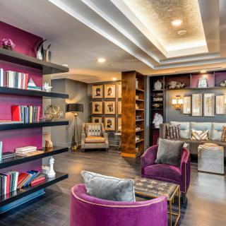 A modern library with vibrant purple chairs and stylish bookshelves, creating a cozy reading nook.