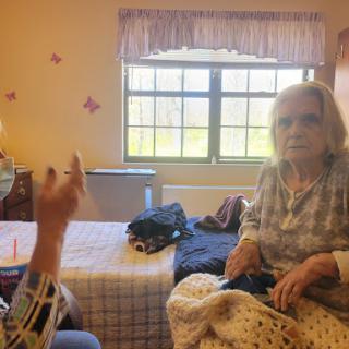 Two seniors engaged in a conversation in a cozy room.