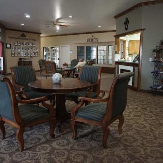 A cozy seating area with a round table and four chairs, surrounded by warm decor in a living room setting.