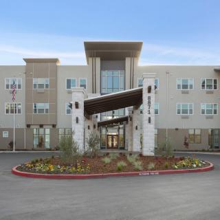 A modern building with a landscaped entrance and a distinctive architectural design.