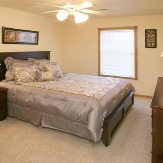 A cozy bedroom with a bed, ceiling fan, and window.
