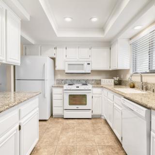 A bright kitchen with white cabinets and modern appliances.