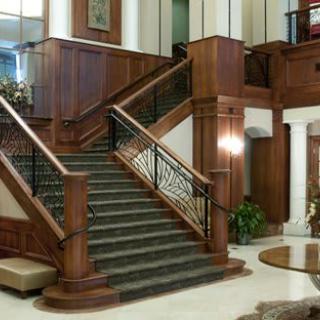 An elegant lobby featuring a grand staircase with wood paneling and classic interior design.