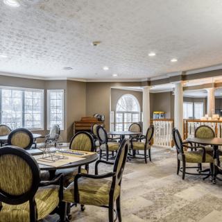 A well-lit dining room with elegantly arranged tables and chairs.