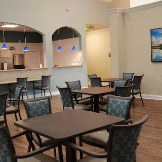 A modern cafe interior with tables and chairs arranged neatly under stylish pendant lights.
