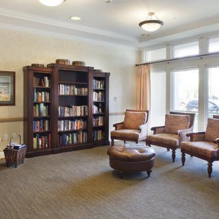 A cozy library room with bookshelves and comfortable seating.