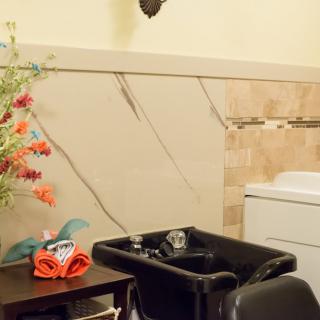 A cozy hair salon corner featuring a washing station and vibrant floral decor.