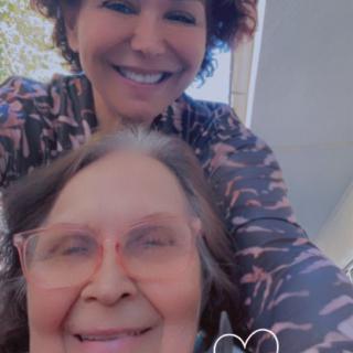 A joyful selfie of two smiling individuals enjoying a moment outdoors.