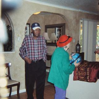Two people wearing hats standing in a living room area.