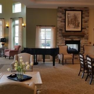 A cozy living room with a piano and fireplace.