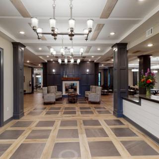 A modern lobby with a chandelier, seating area, and fireplace.