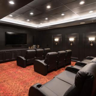 A luxurious home theater with comfortable seating and a large screen.
