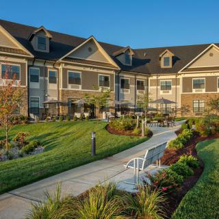 A well-maintained residential building with landscaped gardens and a walking path.
